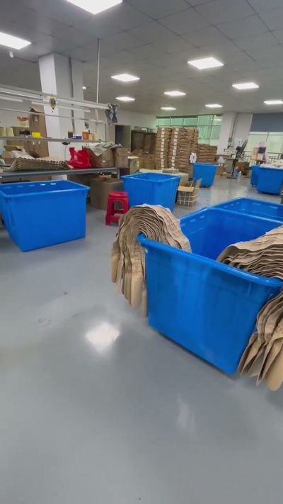 Blue material bins and stacked components in a production workspace.